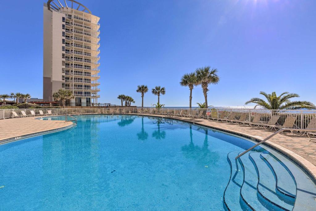 a large blue pool with palm trees and a tall building at Oceanfront Corner-Unit Condo on Perdido Key! in Pensacola