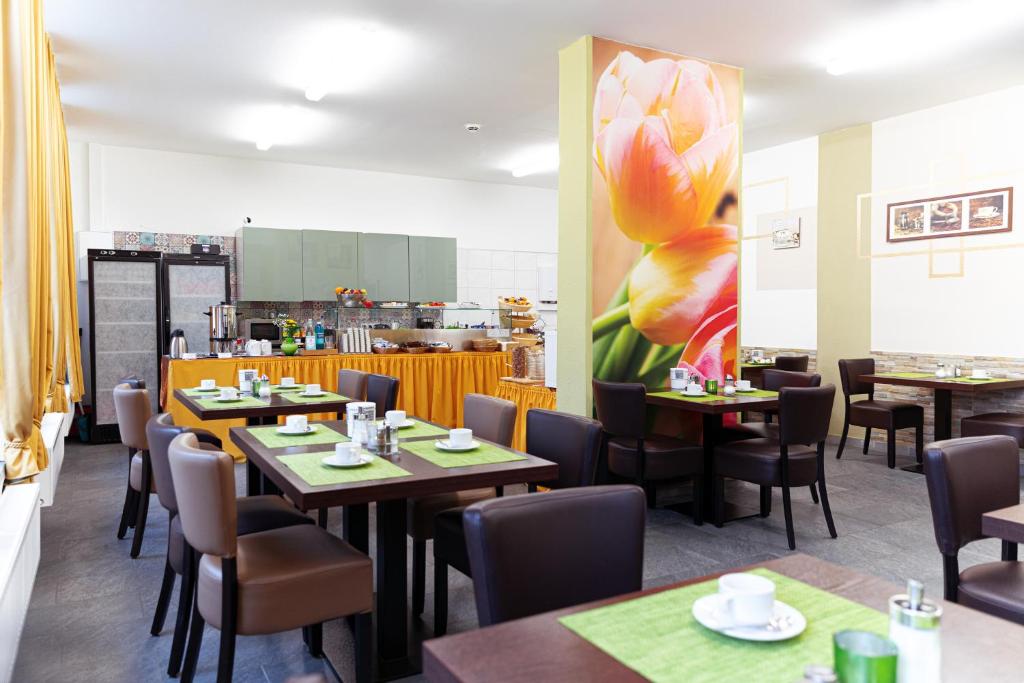 a restaurant with tables and chairs and a flower on the wall at Hotel Polonia - Frankfurt&#47;Oder in Frankfurt Oder