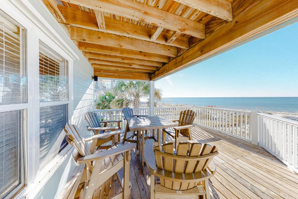 a porch with a table and chairs and the ocean at Jenny Lind East - Nordic Villas in Orange Beach