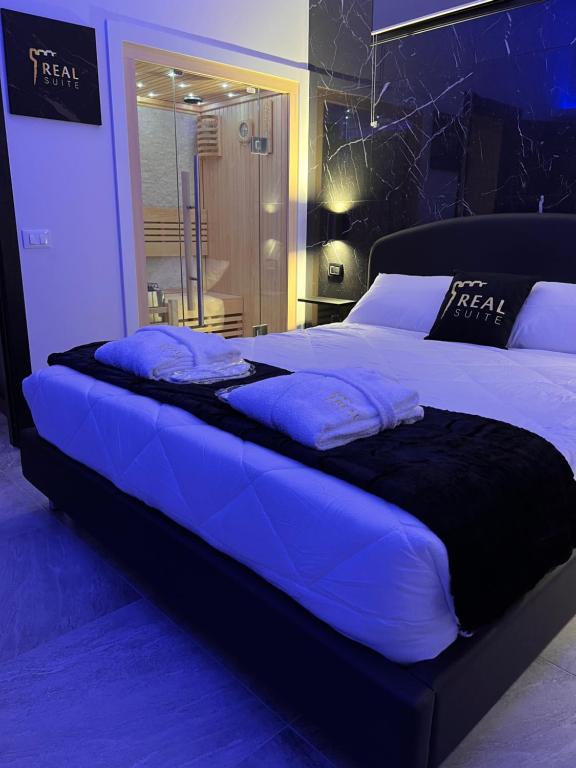 a large bed in a bedroom with blue lighting at Real suite spa in Palermo