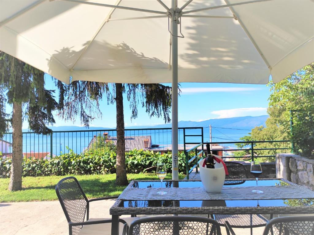 a table with a white umbrella on a patio at PALMA TRSAT with free private parking in Rijeka