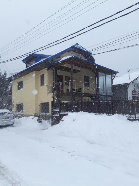 une maison dans la neige à l'avant dans l'établissement Vila Lavinia, à Buşteni