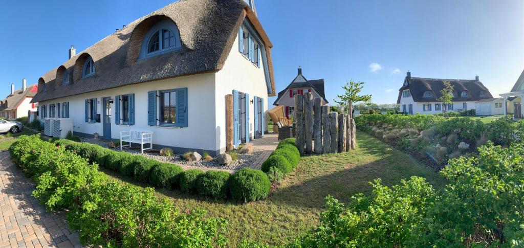 a large white house with a thatched roof at Emilias Hüs, Reethaus in der Bucht von Wismar in Zierow