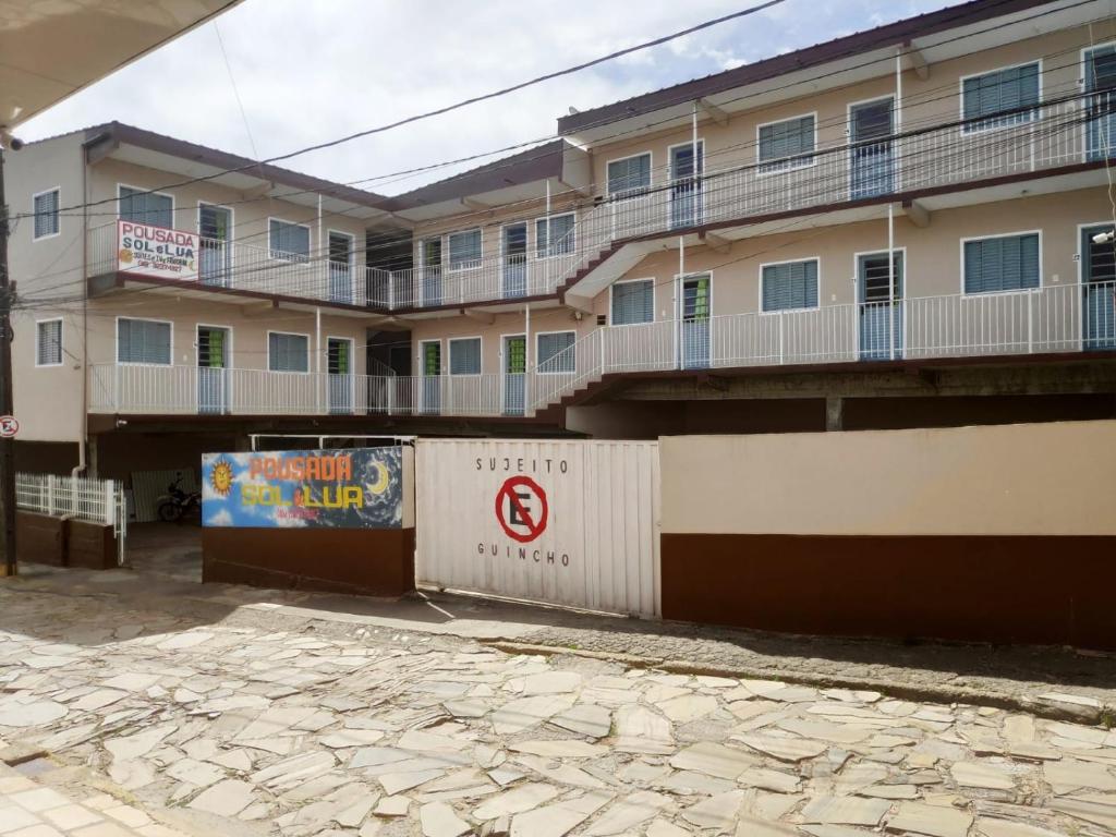 un edificio de apartamentos con un cartel delante en Pousada Sol e Lua, en São Thomé das Letras