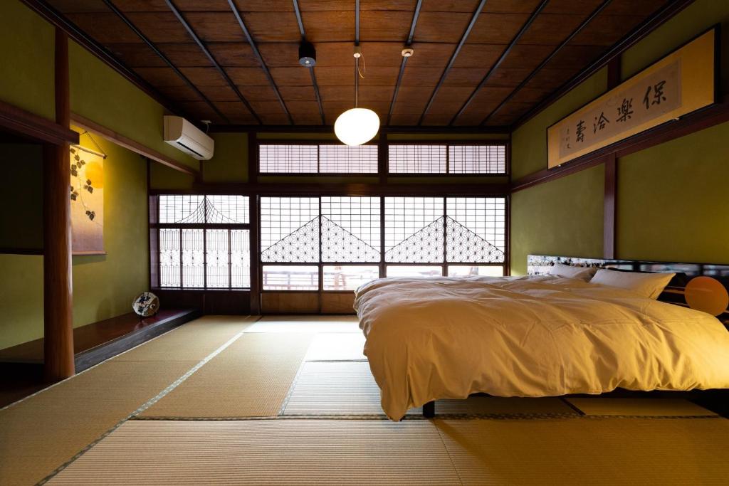 a bedroom with a bed and a large window at Ryusuke25 - Vacation STAY 71742v in Komatsu