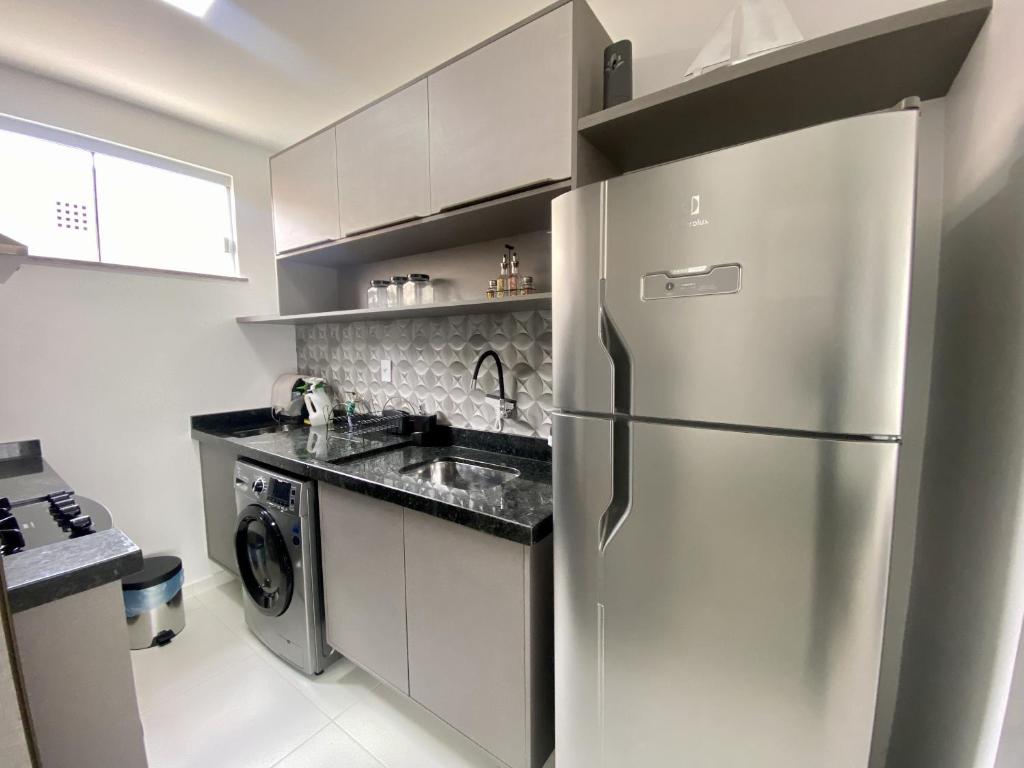 a kitchen with a stainless steel refrigerator and a dishwasher at Dona Olivia Residencial in Vitória da Conquista