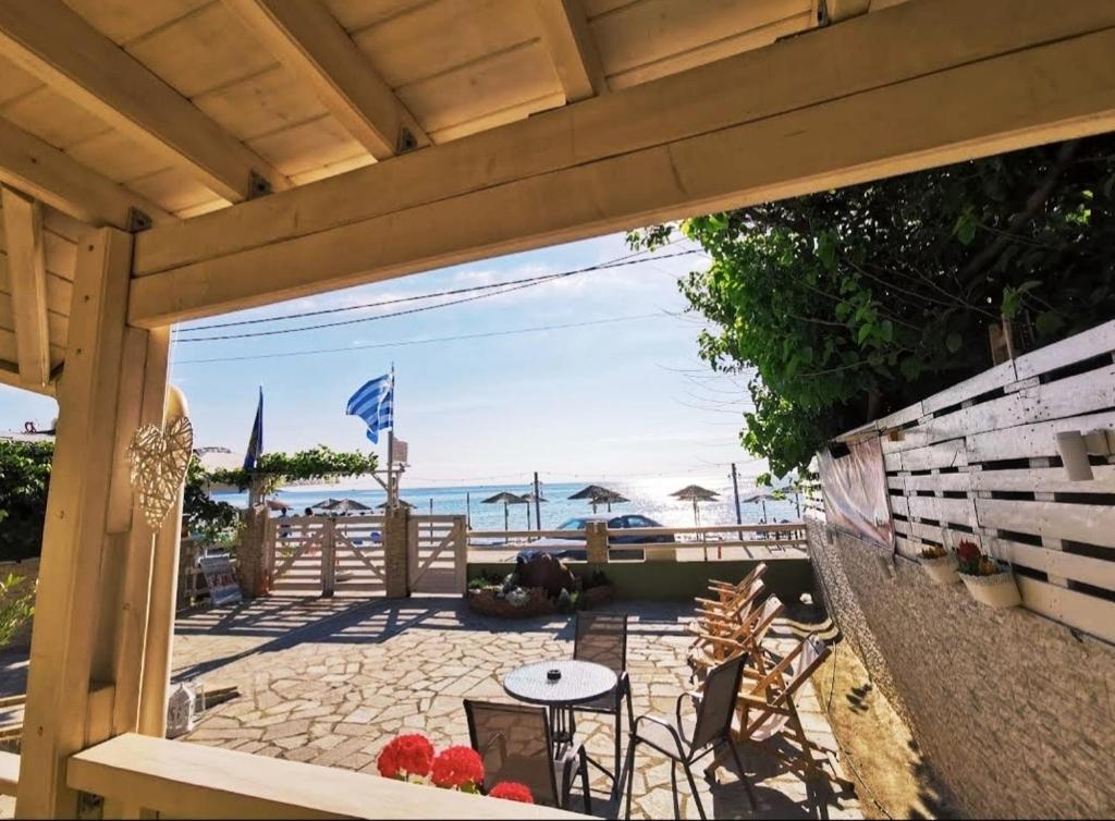 a patio with a table and chairs and the beach at Suites Pierion Musses in Skala Potamias