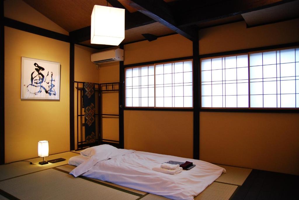 a room with a bed with white sheets and a window at Kanazawa Hitomuneyado Kaisen - Vacation STAY 94237v in Kanazawa