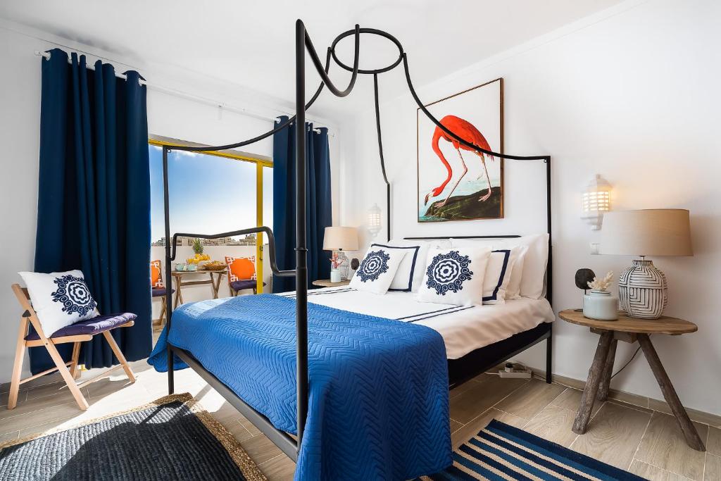 sypialnia z łóżkiem z baldachimem i niebieskim kocem w obiekcie stylish apartment with marina view and aircon w mieście Portimão