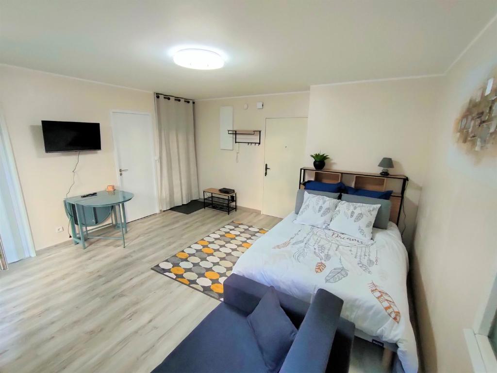 ein Schlafzimmer mit einem Bett und einem blauen Sofa in der Unterkunft Lovely flat nearby Paris fully redone with free parking on premises and balcony in Clichy