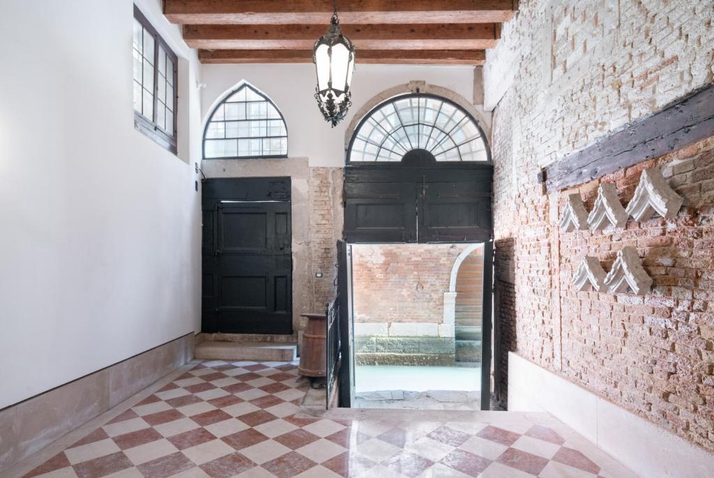 a hallway with a black door and a brick wall at Apartment Sisila in Venice