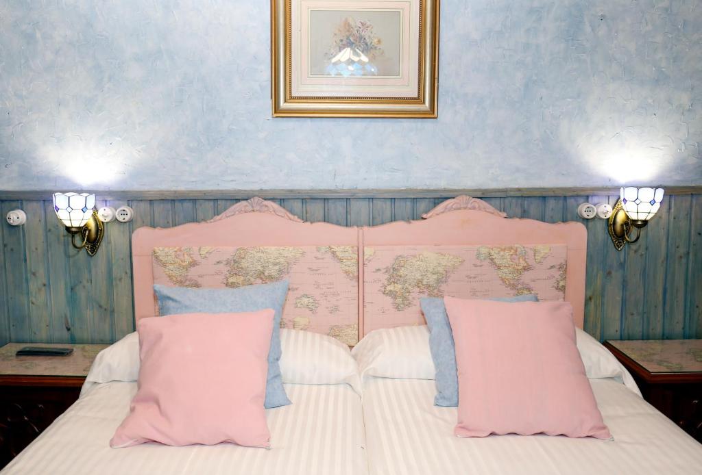 una camera con letto rosa e bianco con cuscini di CASA SAVIOR a Lourenzá