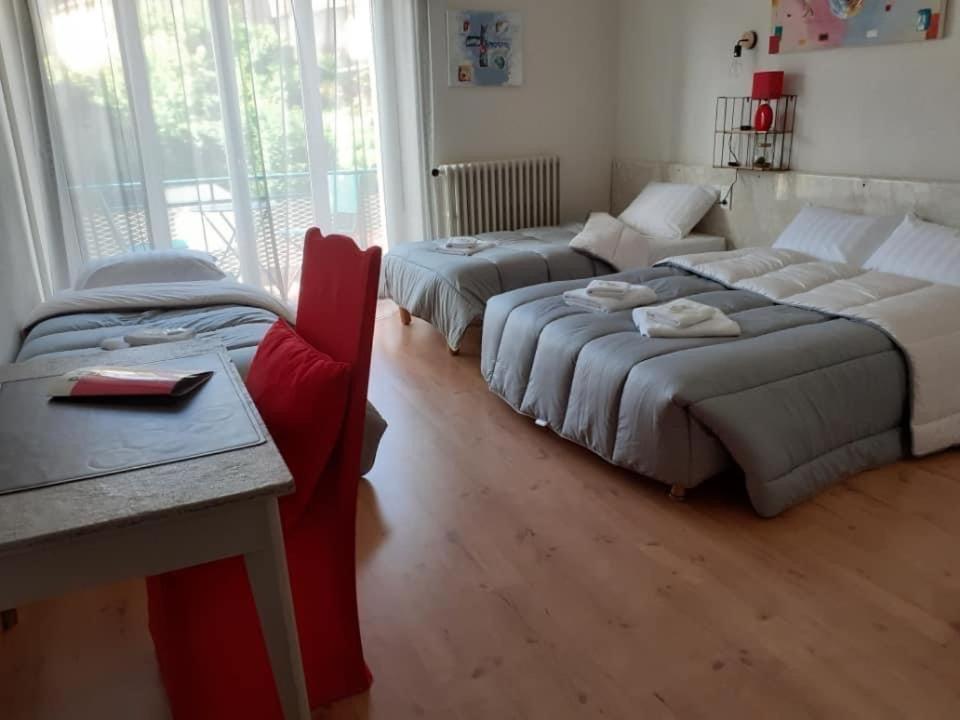 um quarto com duas camas, um sofá e uma mesa em Hotel Bayle em Belcaire