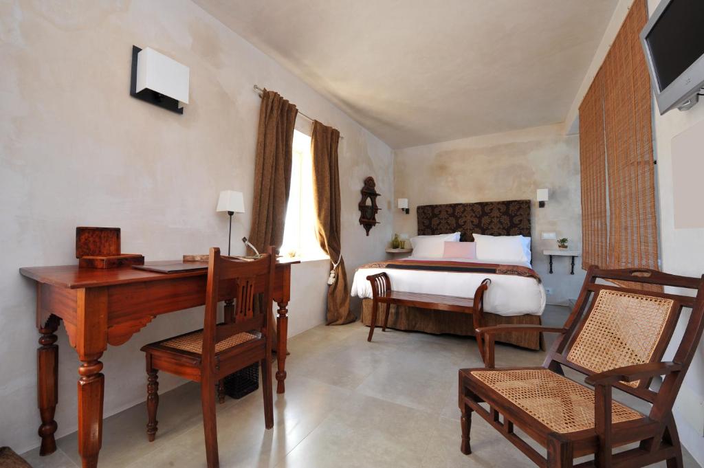 a bedroom with a bed and a desk and a desk at Hotel Boutique V in Vejer de la Frontera