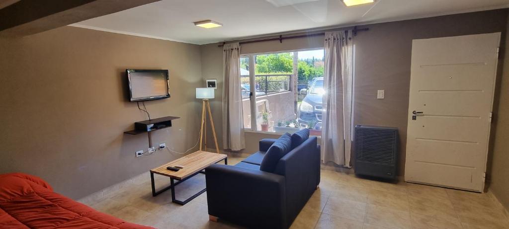 Una sala de estar con un sofá y un televisor. en El Gran Montañes, en Lago Puelo