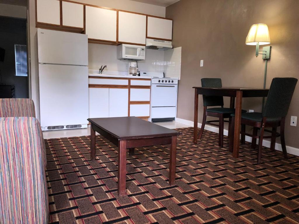 Affordable Suites Burlington في برلنغتون: مطبخ صغير مع طاولة وطاولة وكراسي