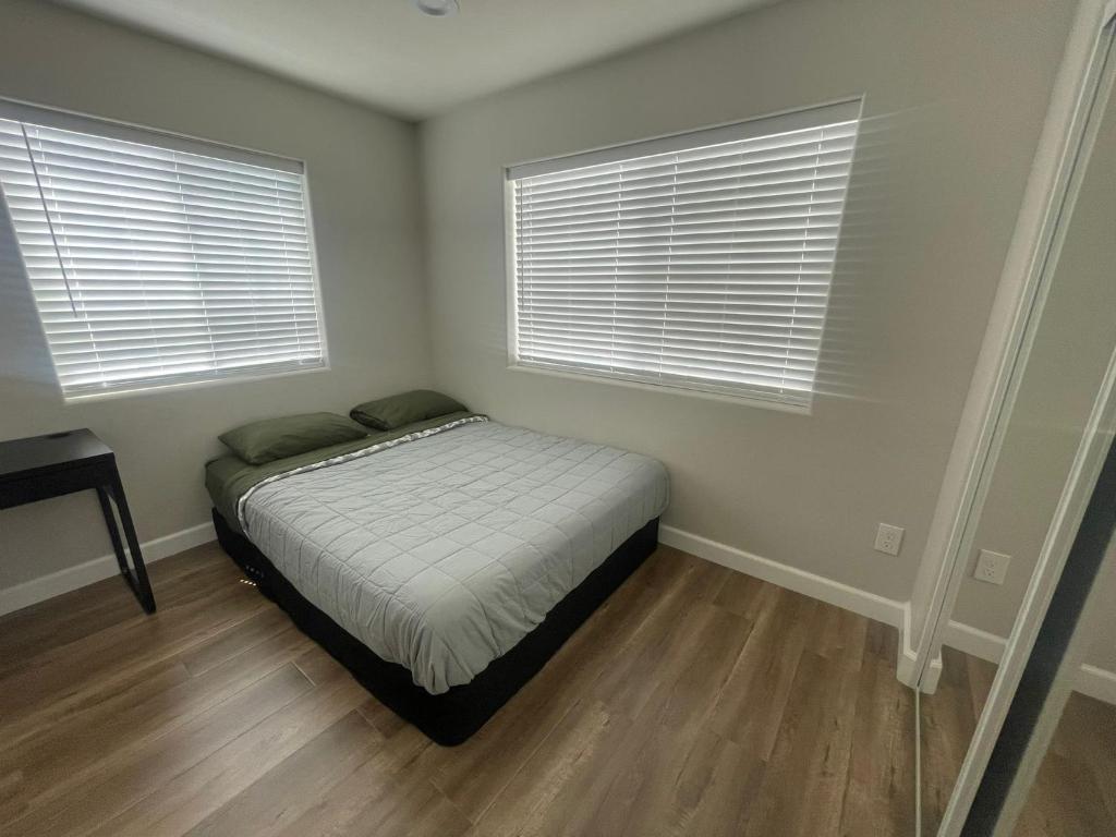 a small bedroom with a bed and two windows at Humble Home Santa Ana 2 in Santa Ana