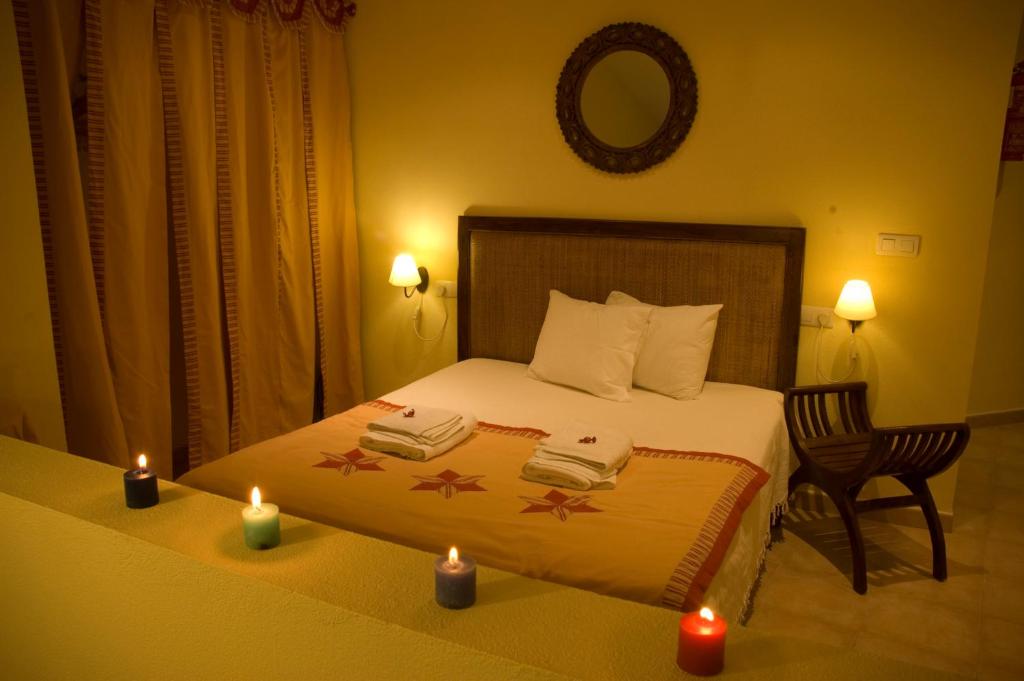 a bedroom with a bed with two candles on it at Bozquez Rural in Alájar