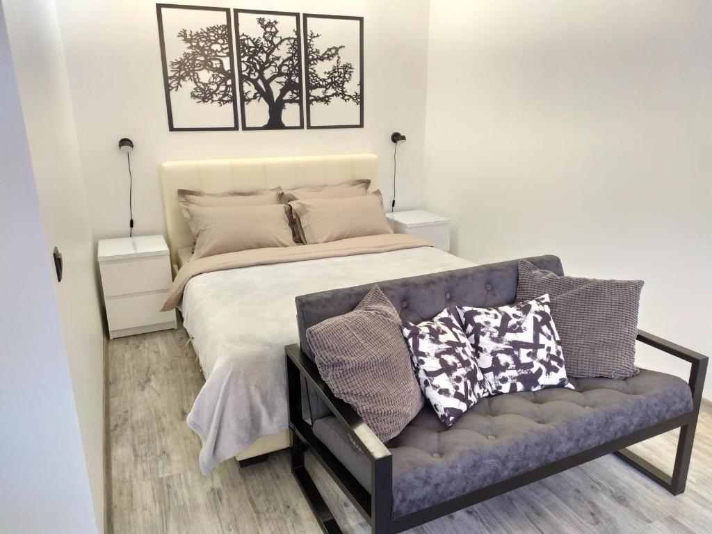 ein Schlafzimmer mit einem Bett und einem Sofa mit Kissen in der Unterkunft Black&white apartment on Saksaganskogo in Kiew