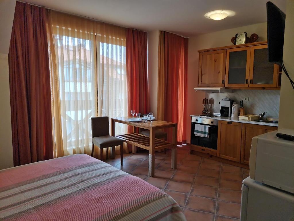 a room with a bed and a table and a kitchen at Studio in Murphys Lodge in Bansko