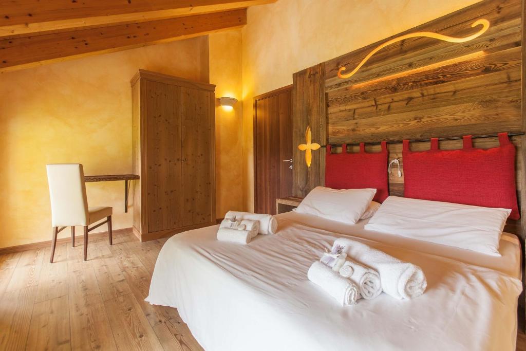 - une chambre avec un grand lit et des serviettes dans l'établissement Residence Samont, à Arta Terme