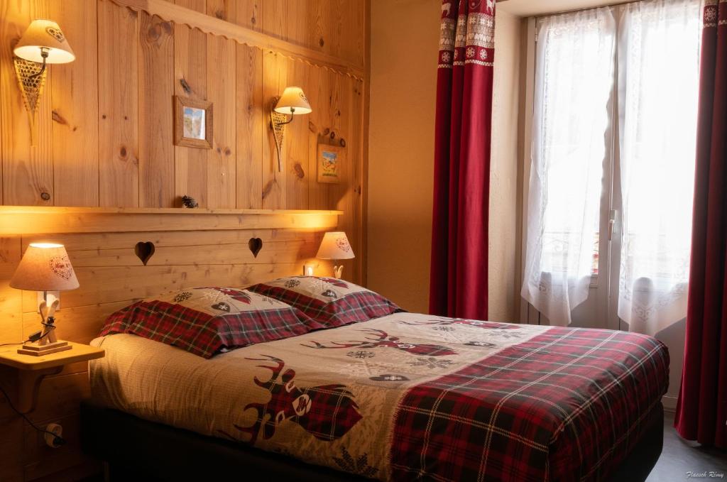 コトレにあるHôtel Le Pas de L'Oursのベッドルーム1室(ベッド1台、赤いカーテン付)
