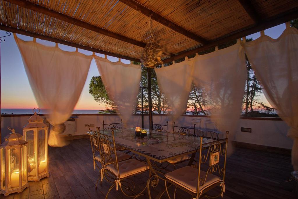 a dining room with a table and chairs and the sunset at Lacco Terrace Solarium in Ischia