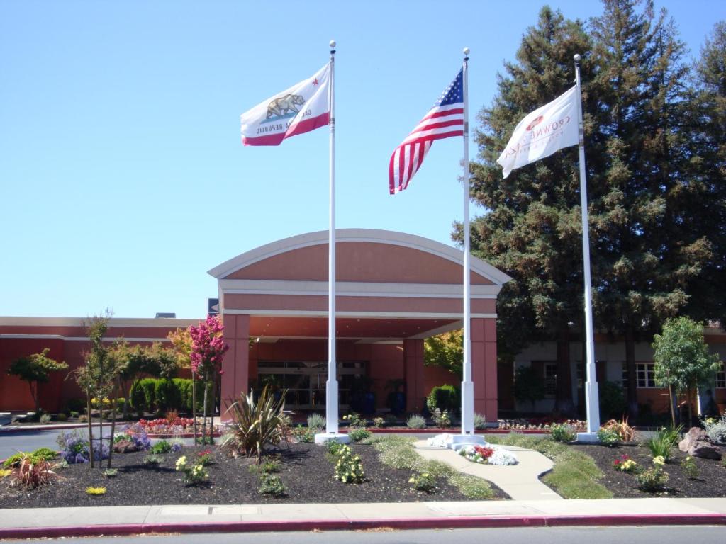 two american flags flying in front of a building at Concord Plaza Hotel in Concord