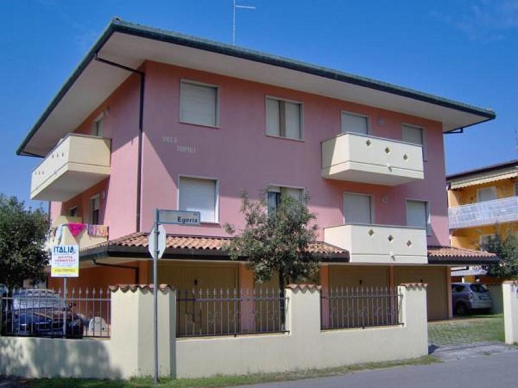 un edificio rosa con una valla delante en Villa Tripoli, en Bibione