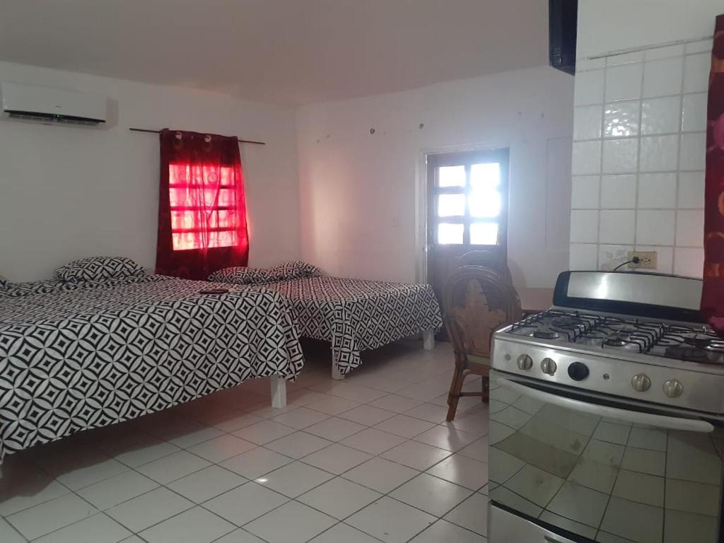 a room with a stove and a bed and a kitchen at Calinago Friendly Family Sxm in Philipsburg