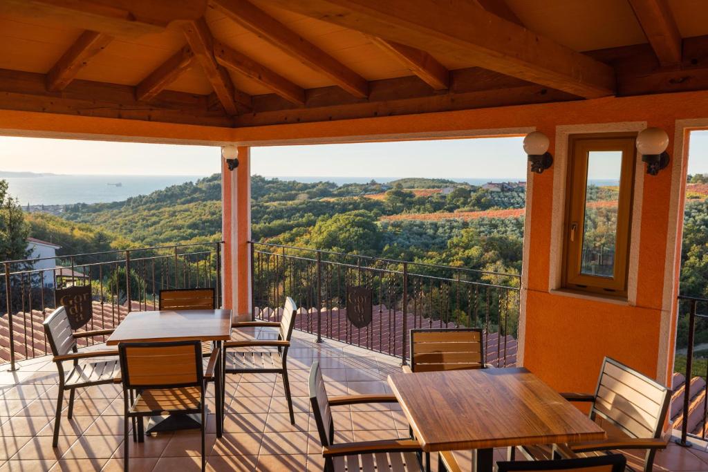 a balcony with tables and chairs and a view of the mountains at Gordia organic winery in Hrvatini