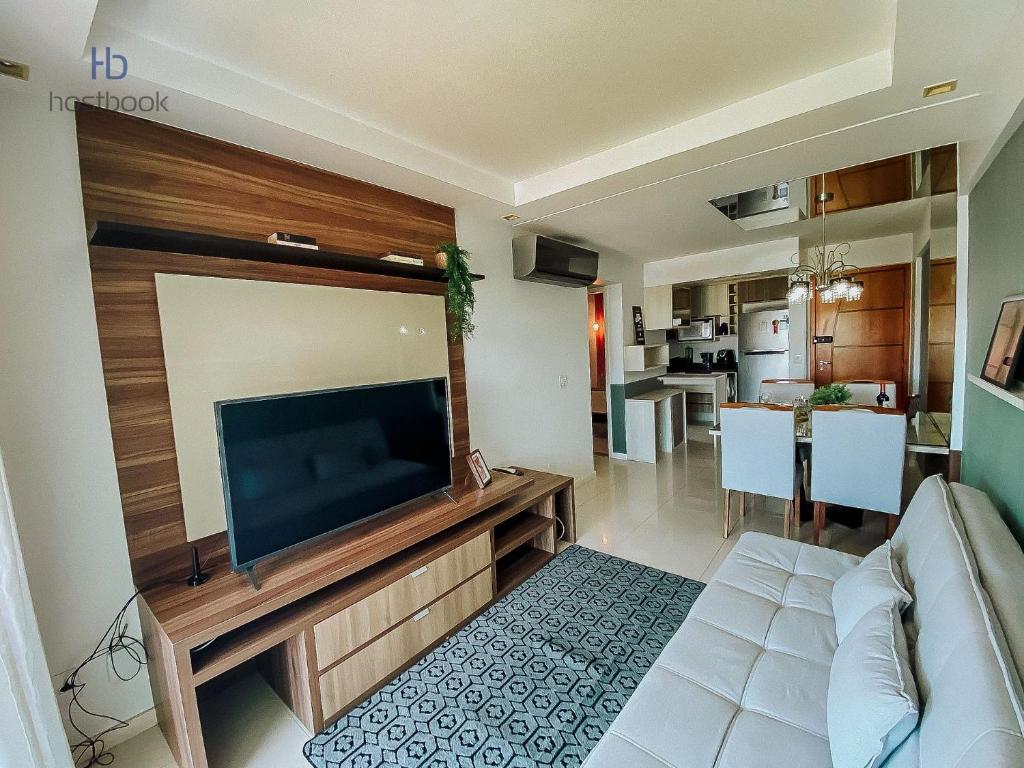 sala de estar con TV de pantalla plana grande en Apto espetacular no Pecado entre MAR e LAGOA - WIFI 200MB - Piscina com vista - Garagem - 2 Quartos - TV Smart - Cozinha equipada - Churrasqueira - Ar condicionado, en Macaé