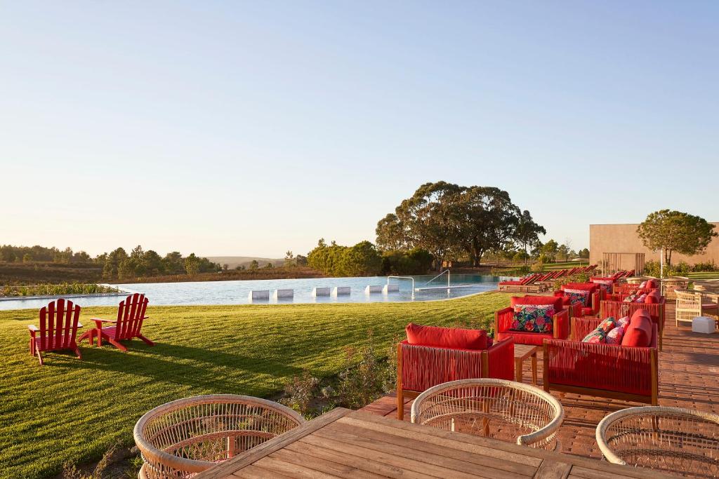 a row of chairs on a deck next to a body of water at Praia do Canal Nature Retreat in Aljezur