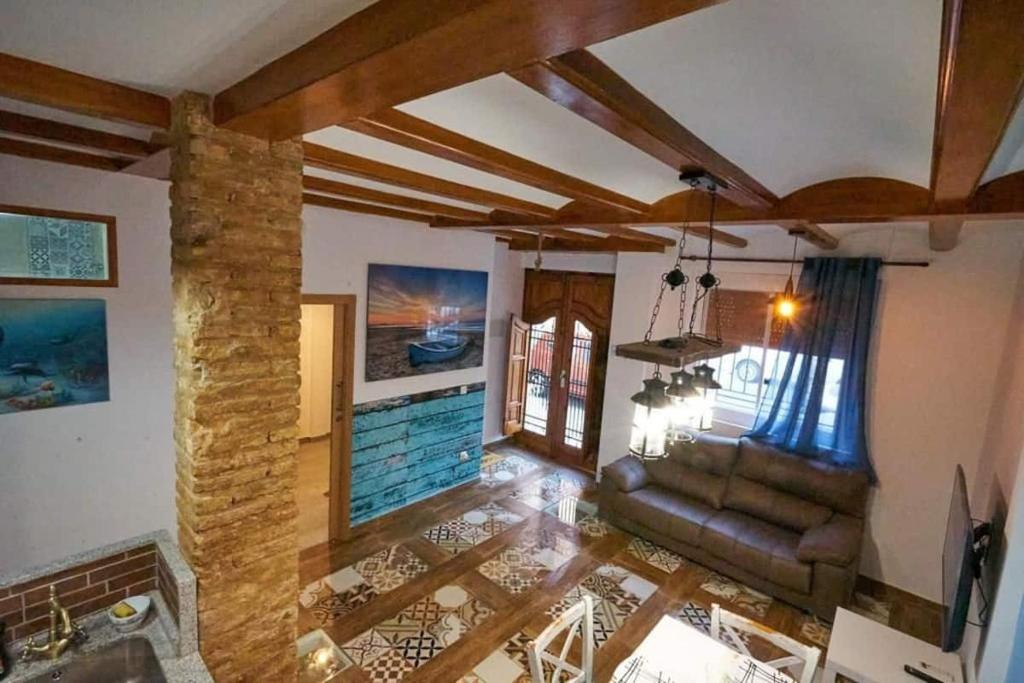 sala de estar con sofá y pilar de piedra en Casa ideal para familias con patio y 3 baños, en Valencia