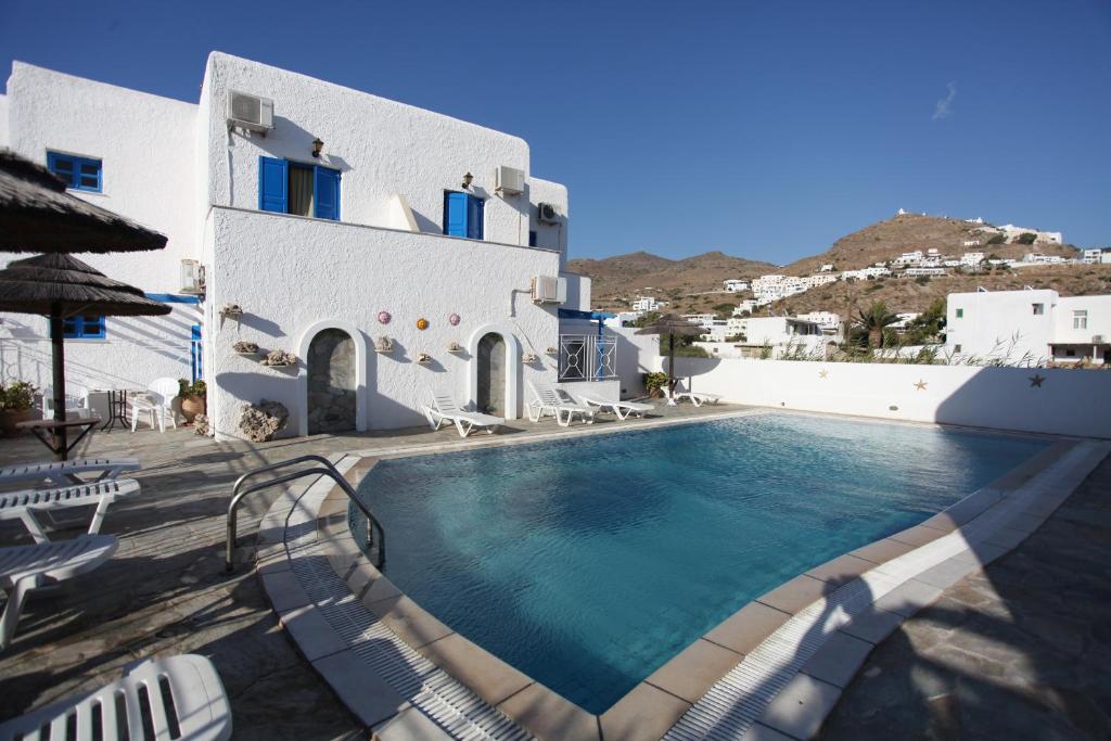 a swimming pool in front of a white building at Mare Monte in Ios Chora