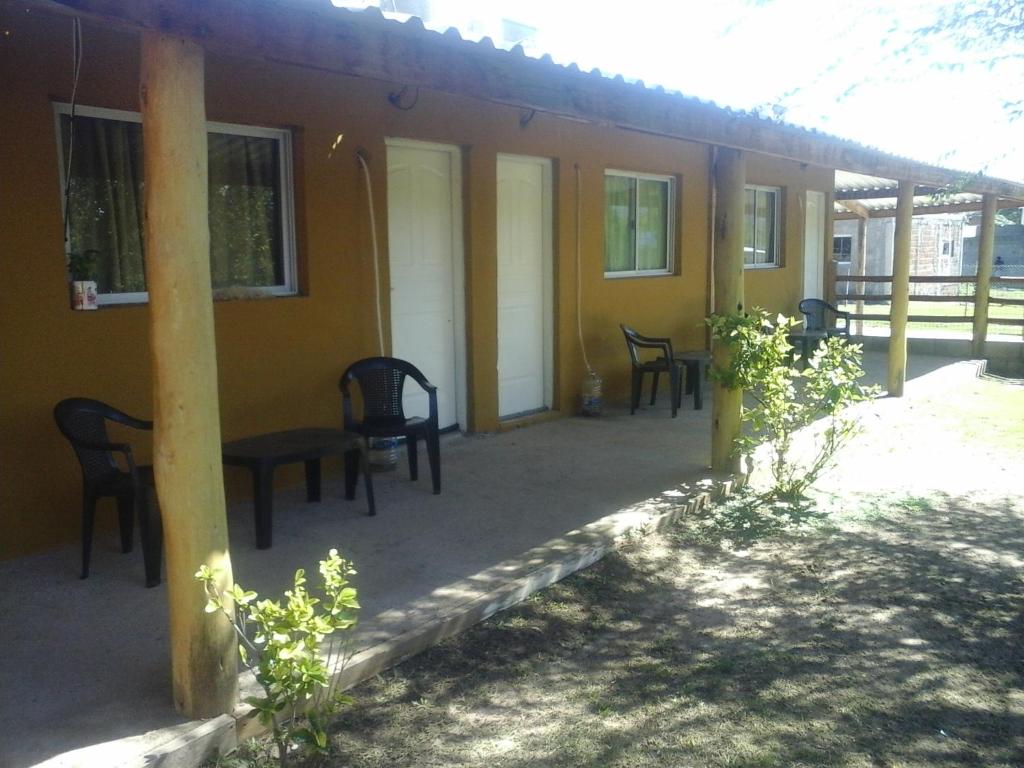 a porch of a house with chairs and a table at LUMALU Deptos in Villa Cura Brochero