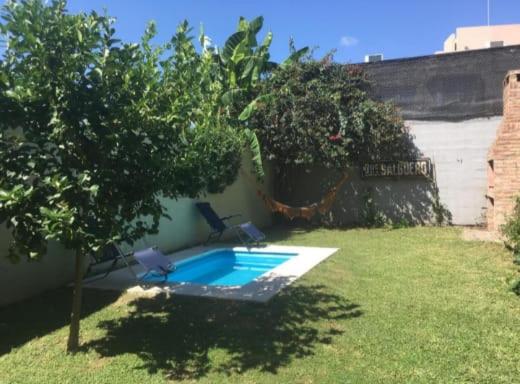 einen Pool mit zwei Stühlen im Hof in der Unterkunft Casa y departamento con pileta Aeropuerto Circunvalacion Kempes Quorum -cambio oficial- in Cordoba