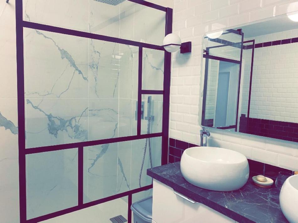 La salle de bains est pourvue d'un lavabo et d'une douche en verre. dans l'établissement Super apt Parking + Clim 5 min du centre & gare, à Sète