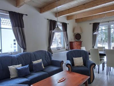 uma sala de estar com dois sofás azuis e uma mesa em Ferienhaus FH8 em Graal-Müritz