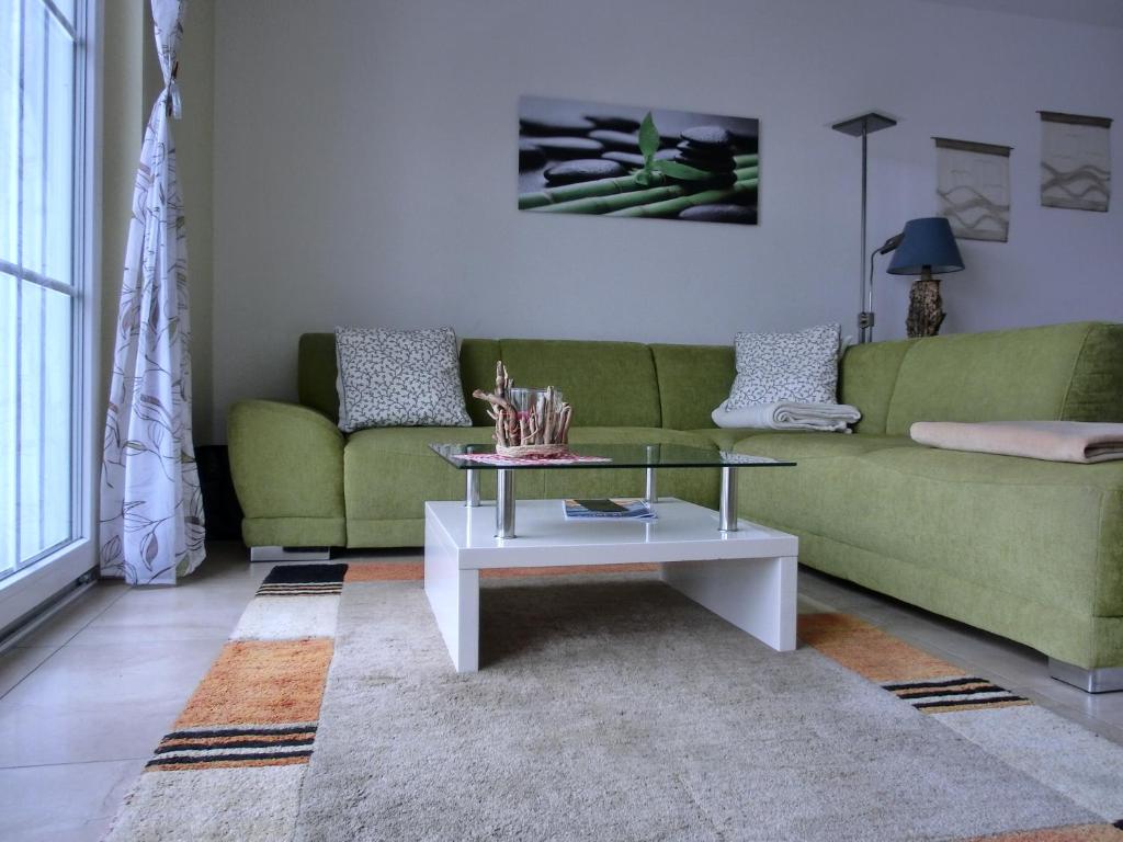 uma sala de estar com um sofá verde e uma mesa de centro em Ferienwohnung LP7 "Seestern" em Graal-Müritz