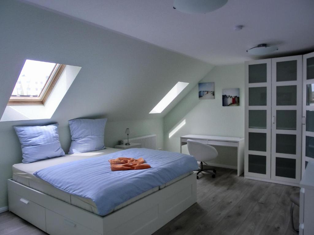 a bedroom with a bed with blue sheets and a desk at Ferienwohnung P15 in Graal-Müritz