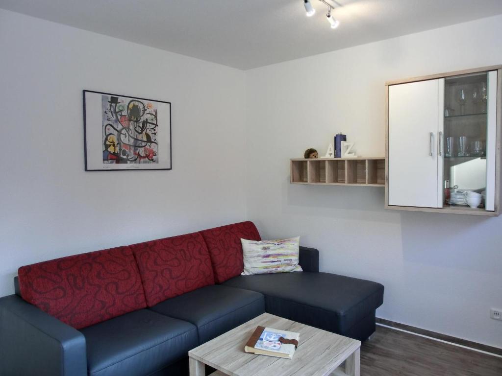 ein Wohnzimmer mit einem roten Sofa und einem Tisch in der Unterkunft Ferienwohnung KWi 38 EG "Borstel" in Graal-Müritz