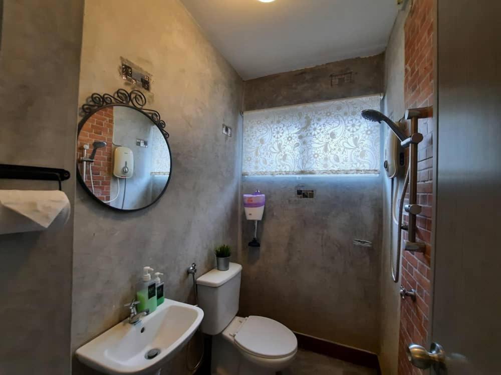 La salle de bains est pourvue de toilettes, d'un lavabo et d'un miroir. dans l'établissement Sunway Alpine Village near Onsen Lost World of Tambun Ipoh Ipoh city, à Ipoh