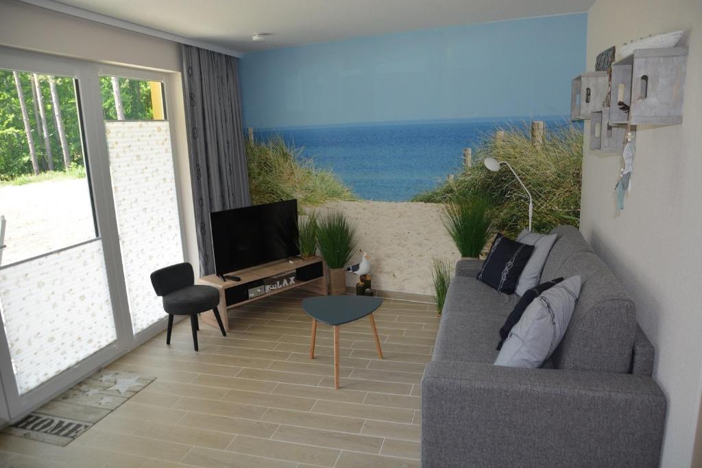 ein Wohnzimmer mit einem Sofa und Strandblick in der Unterkunft Ferienwohnung KWH 1 EG - "Ostseedüne" in Graal-Müritz