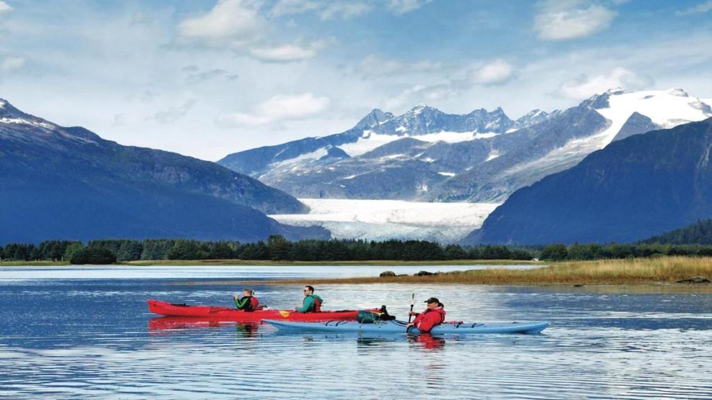 um grupo de pessoas em caiaques em um lago com montanhas em Twin Peaks - Great Location! Walk to Mendenhall Glacier - DISCOUNTS ON TOURS! em Mendenhaven