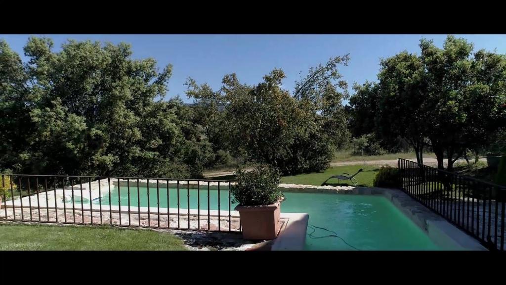 a fence with a potted plant next to a swimming pool at La Casona de Requijada a 6km de Pedraza con Piscina in Requijada