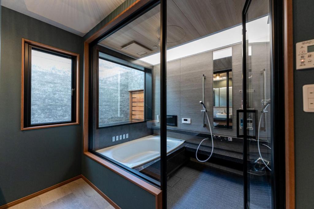 a bathroom with a tub and a large window at HAKATA TERRACE -晴 hare- in Fukuoka