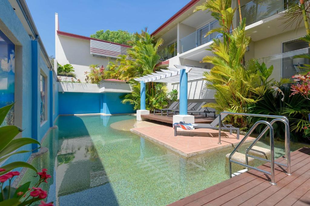 
a patio area with a pool table and chairs at Macrossan House Boutique Holiday Apartments in Port Douglas
