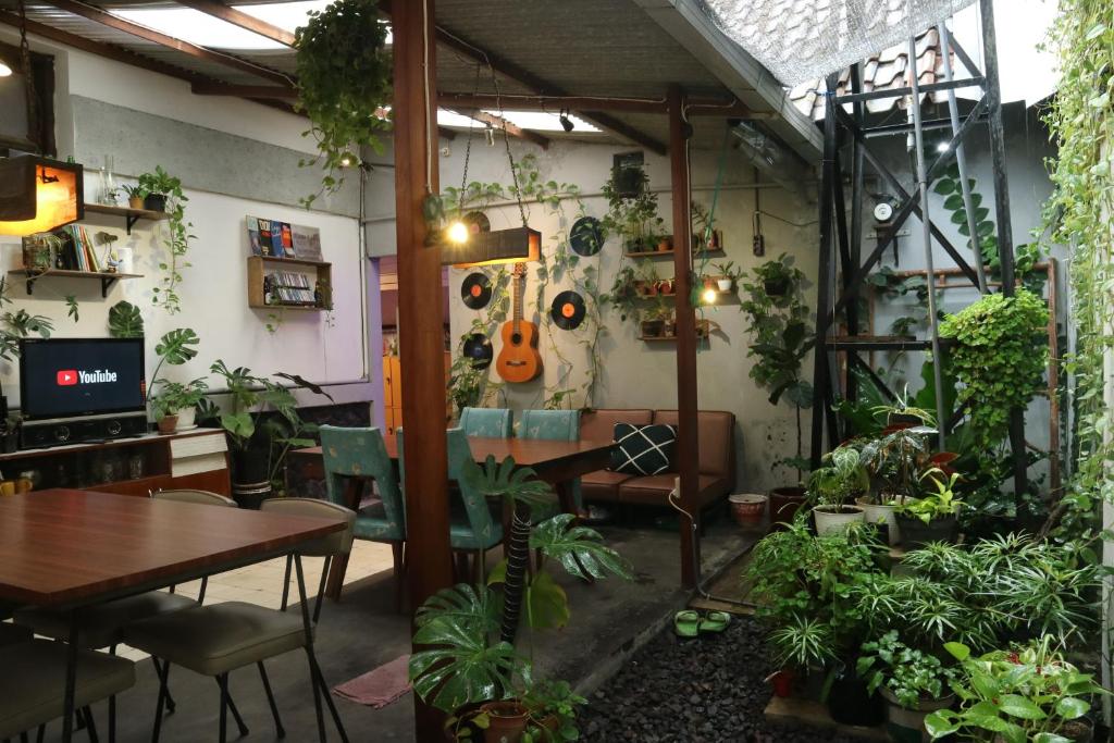 una habitación llena de muchas plantas y una mesa en SEMERU HOSTEL MALANG, en Malang