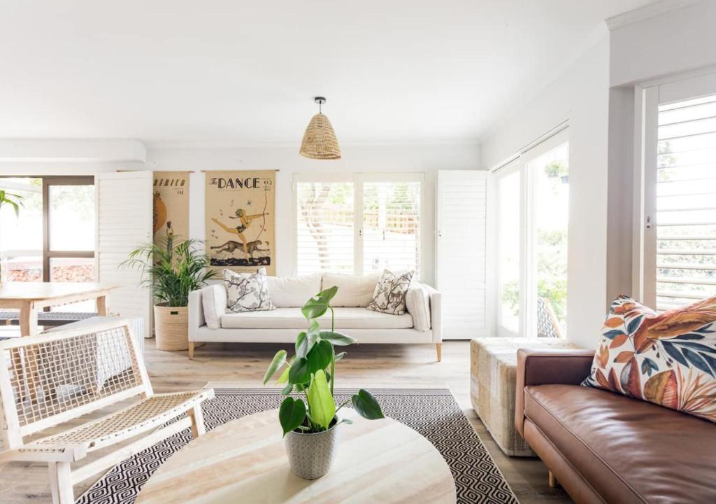 a living room with a couch and a table at Plett Holiday Stay with Hut Tub ,Pizza Oven and Views in Plettenberg Bay